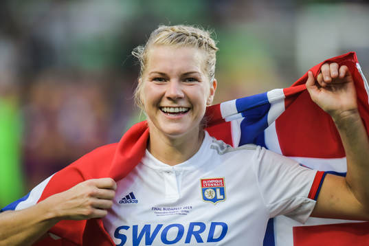 Ada Hegerberg of Lyon celebrates with a Norwegian flag
