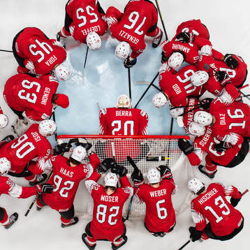 Players of Switzerland gather around goaltender Reto Berra