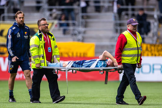 Djurgårdens Aslak Witry bärs av planen på bår