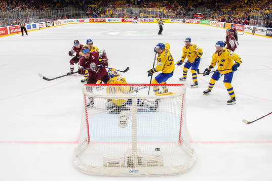 Roberts Bukarts of Latvia score 4-4 behind goaltender