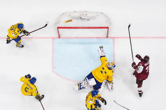 Roberts Bukarts of Latvia scores 4-4 behind goaltender