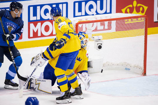 Petteri Lindbohm of Finland scores 2-3 behind goaltender