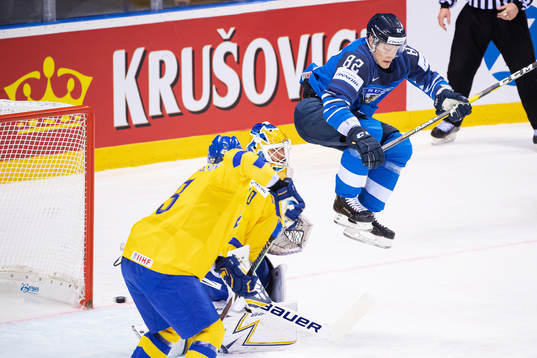 Harri Pesonen of Finland with a jump infront of goaltender