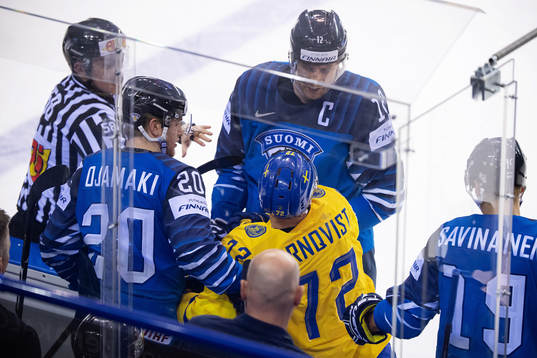 Patric Hörnqvist of Sweden gets tackled into team Finlands