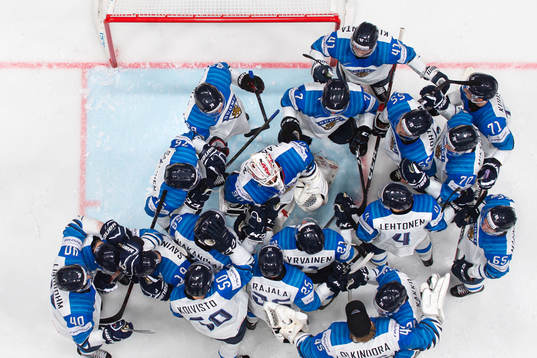Players of Finland gather around goaltender Kevin Lankinen
