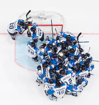 Players of Finland gather around goaltender Kevin Lankinen