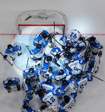 Players of Finland gather around goaltender Kevin Lankinen
