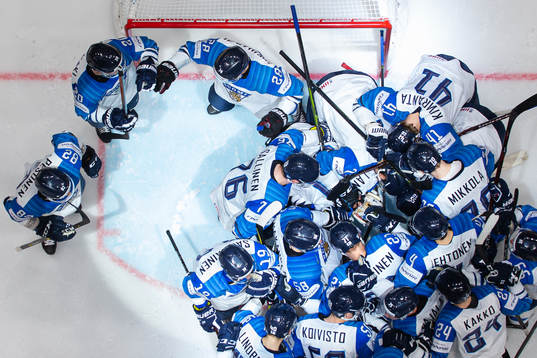 Players of Finland gather around goaltender Kevin Lankinen