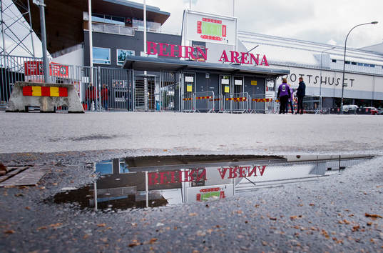 En vattenpöl och entrén till Behrn Arena