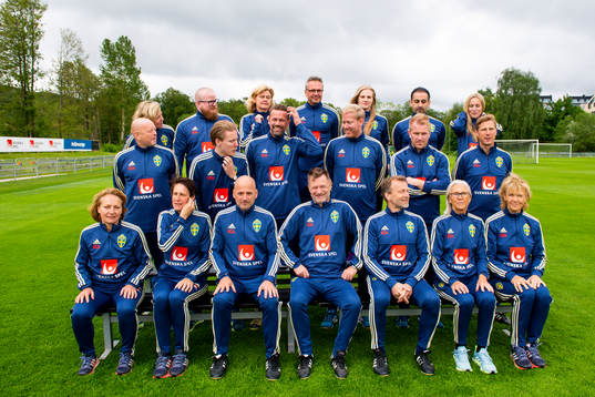 Staff prepare for a team photo shoot with coaching staff of