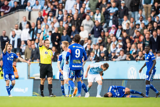 Domare Kristoffer Karlsson delar ut ett gult kort till