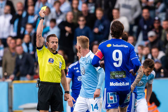 Domare Kristoffer Karlsson delar ut ett gult kort till