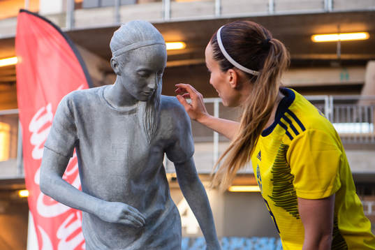 Kosovare Asllani of Sweden next to a statue of herself