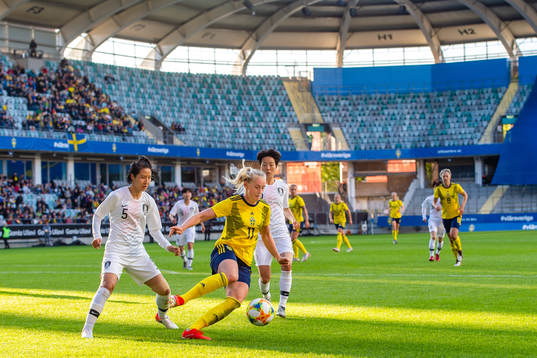 Doyeon Kim of South Korea   and Stina Blackstenius of Sweden