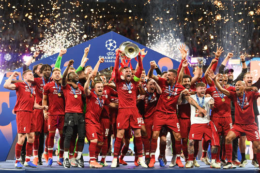 Jordan Henderson of Liverpool raises the throphy in front