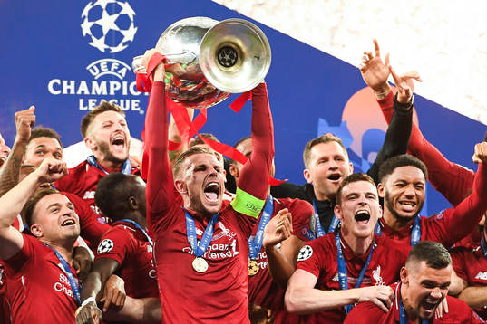 Jordan Henderson of Liverpool raises the throphy in front