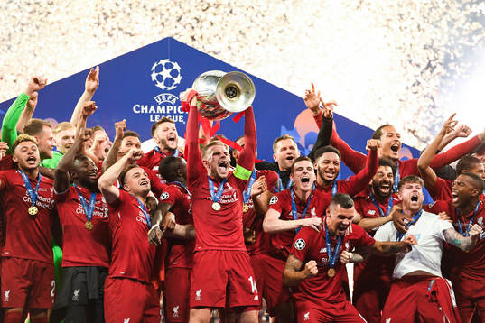 Jordan Henderson of Liverpool raises the throphy in front
