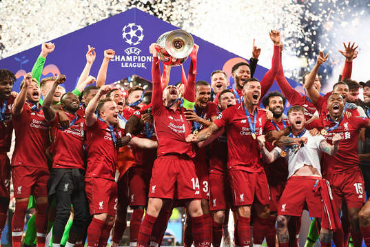 Jordan Henderson of Liverpool raises the throphy in front