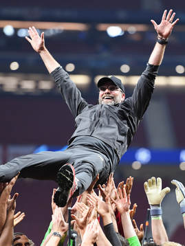 Head coach Jürgen Klopp of Liverpool is raised by the