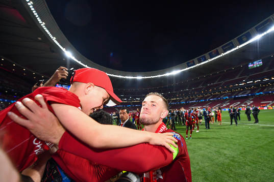 Jordan Henderson of Liverpool lifts a boy as he celebrate