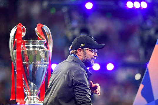 Head coach Jürgen Klopp of Liverpool walks by the trophy