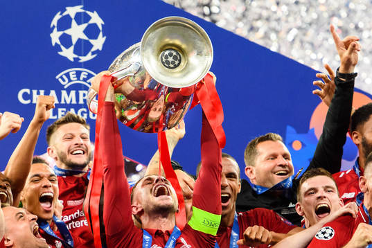 Jordan Henderson of Liverpool raises the throphy in front