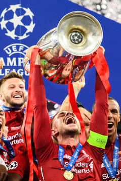 Jordan Henderson of Liverpool raises the throphy in front