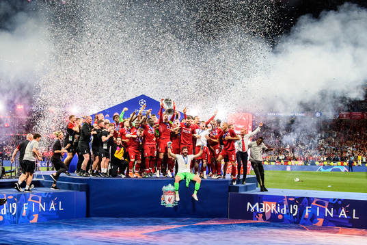 Jordan Henderson of Liverpool raises the throphy in front