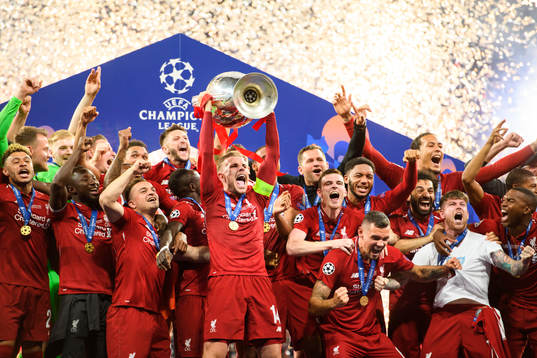 Jordan Henderson of Liverpool raises the throphy in front