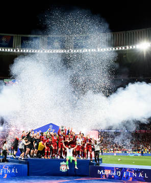 Jordan Henderson of Liverpool raises the throphy in front