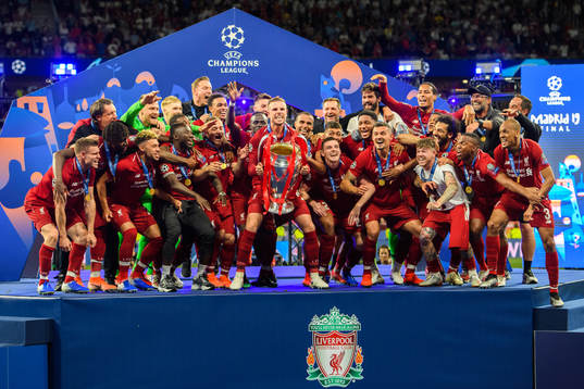 Jordan Henderson of Liverpool raises the throphy in front