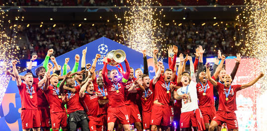 Jordan Henderson of Liverpool raises the throphy in front