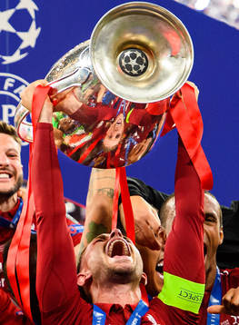 Jordan Henderson of Liverpool raises the throphy in front