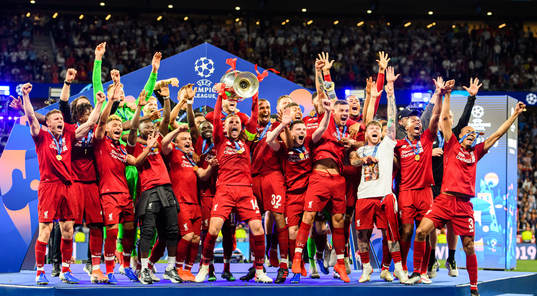 Jordan Henderson of Liverpool raises the throphy in front