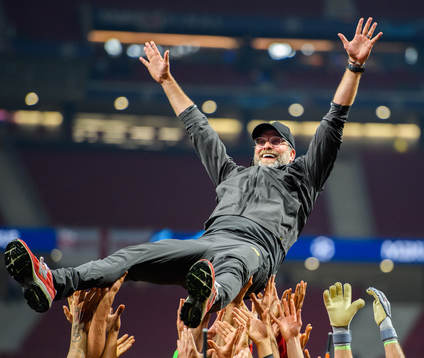 Head coach Jürgen Klopp of Liverpool is raised by the