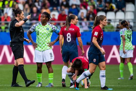 Desire Oparanozie of Nigeria is shown a yellow card