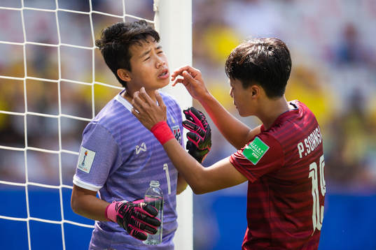Goalkeeper Waraporn Boonsing of Thailand is attended to
