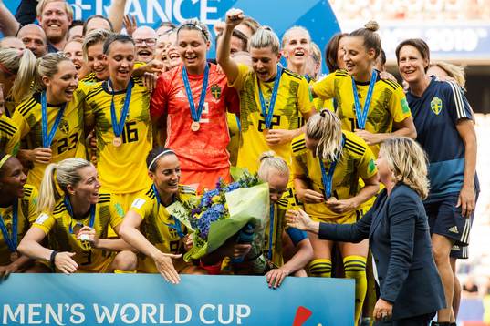 Caroline Seger of Sweden receives flowers for her 200th