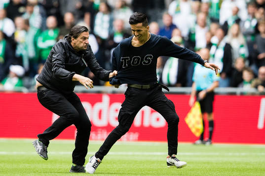 Säkerhetspersonal från Hammarby stoppar en åskådare som