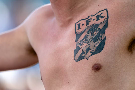 IFK Göteborgs emblem tatuerat på bröstet av en supporter