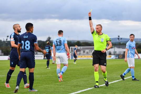 Romain Gall of Malmö FF is shown a yellow card from
