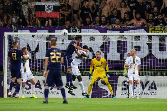 Players compete for the ball in front of goalkeeper Oscar
