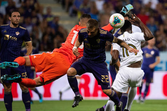 Goalkeeper Kenan Piric and Martin Milec compete for the