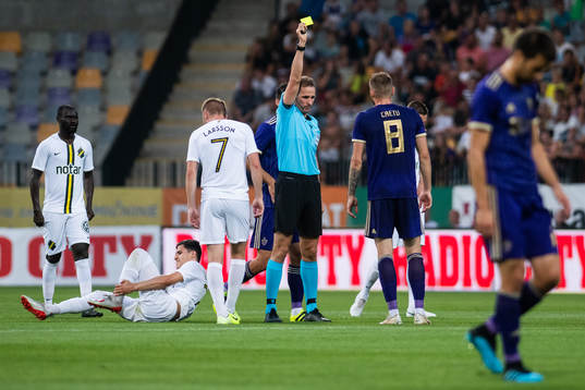 Referee Sascha Stegemann gives a yellow card to Alexandru
