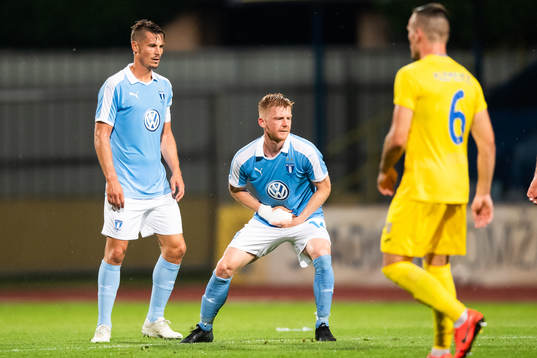 Anders Christiansen of Malmö FF reaches for his injured