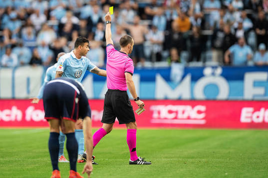 Behrang Safari of Malmö FF is shown a yellow card by