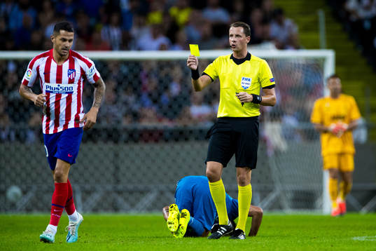 Referee Andreas Ekberg gives a yellow card to Victor Machin
