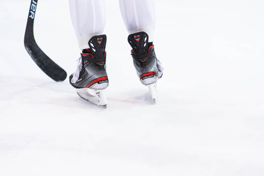 Klubba och skridskor på en träning med ishockeylaget