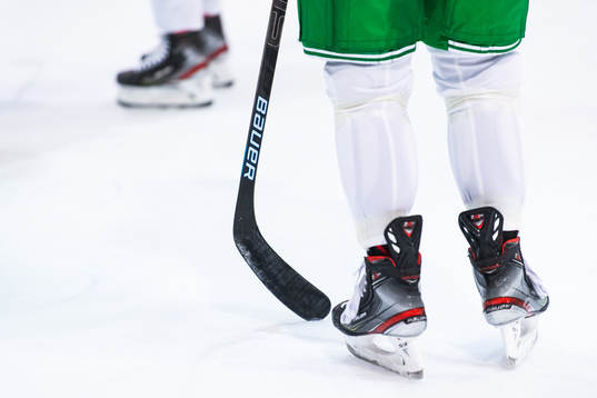 Klubba och skridskor på en träning med ishockeylaget