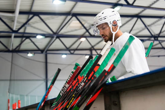 Mattias Sjögren tittar på ishockeyklubbor som står